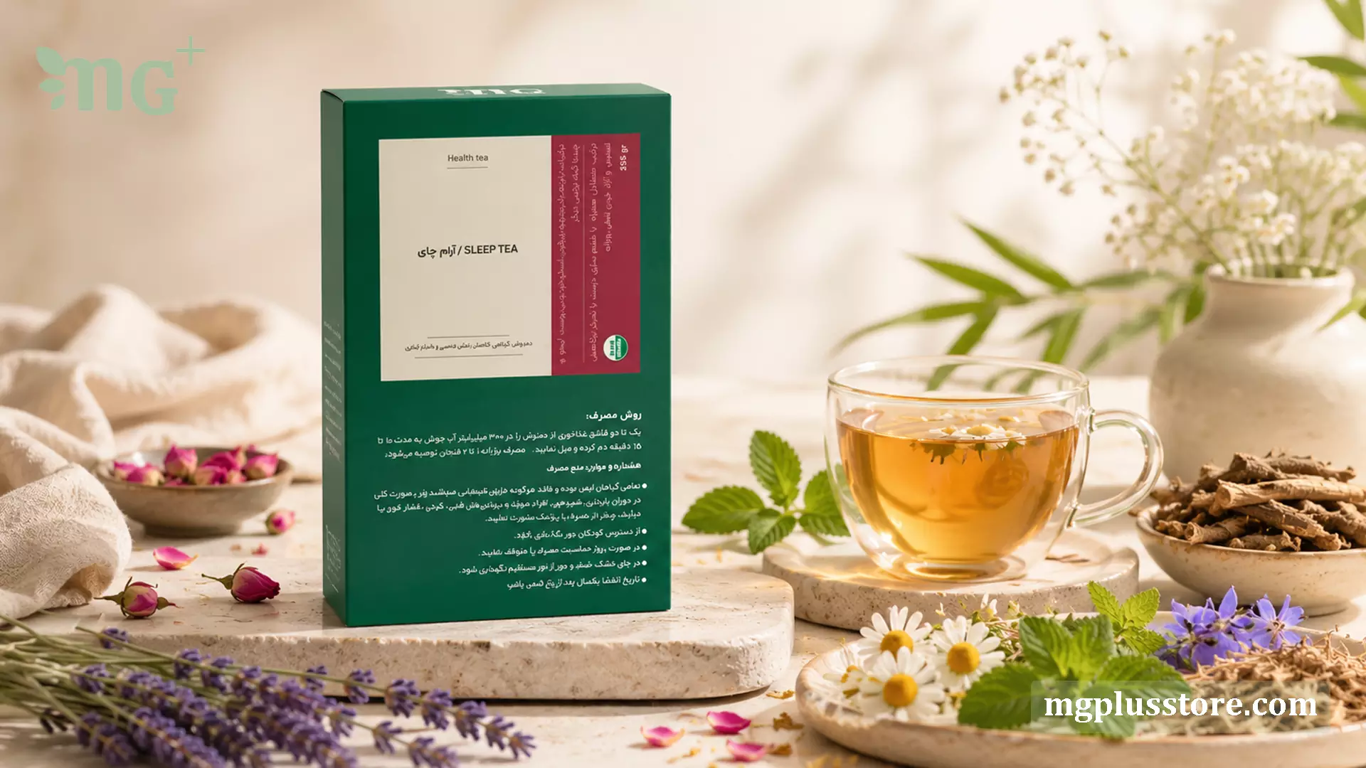 جعبه دمنوش آرام چای MG Plus در کنار فنجان دمنوش گیاهی و گل‌های بابونه، اسطوخودوس و نعناع