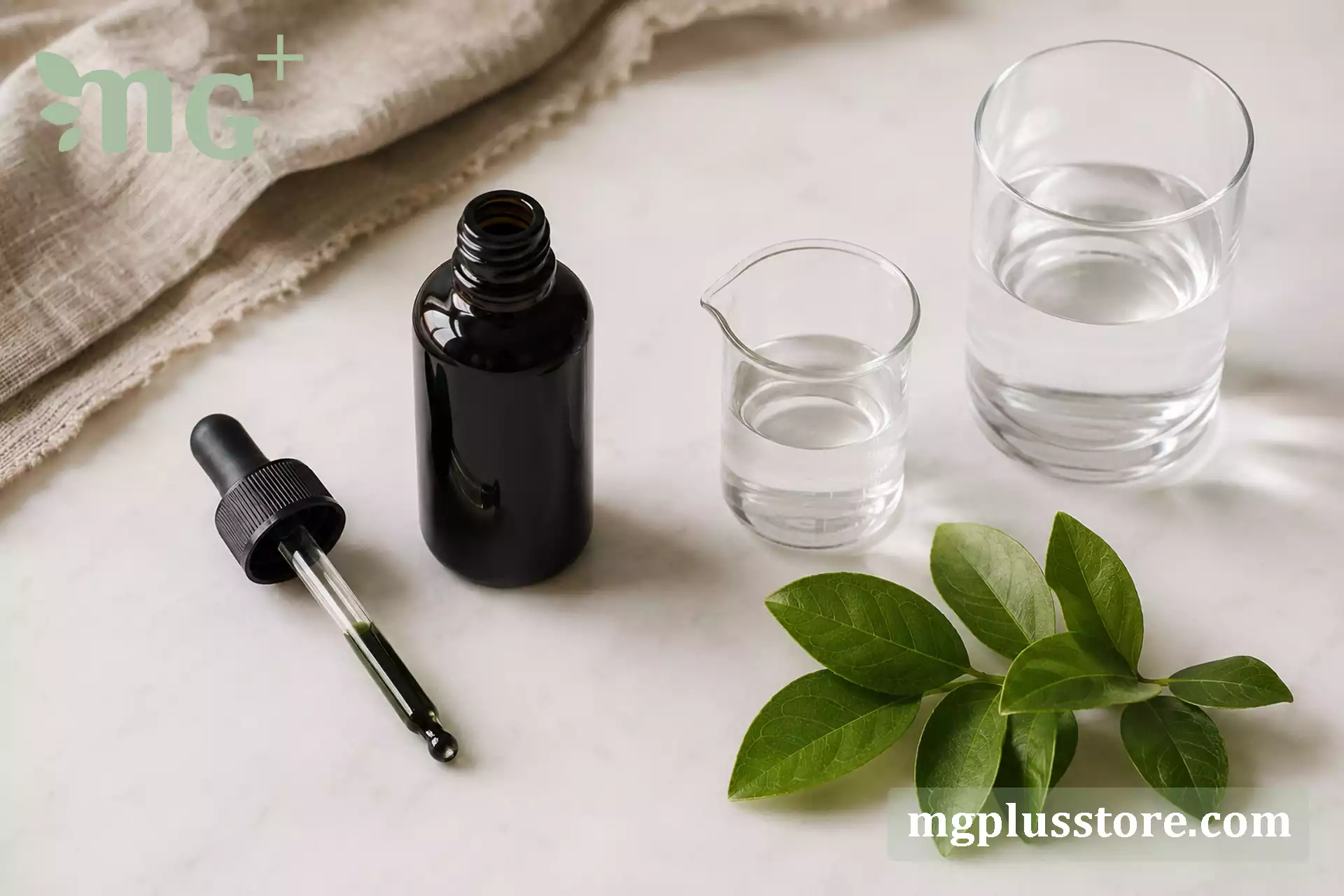 بطری کلروفیل، قطره‌چکان، پیمانه و لیوان آب با چیدمان منظم روی سطح سفید گرم